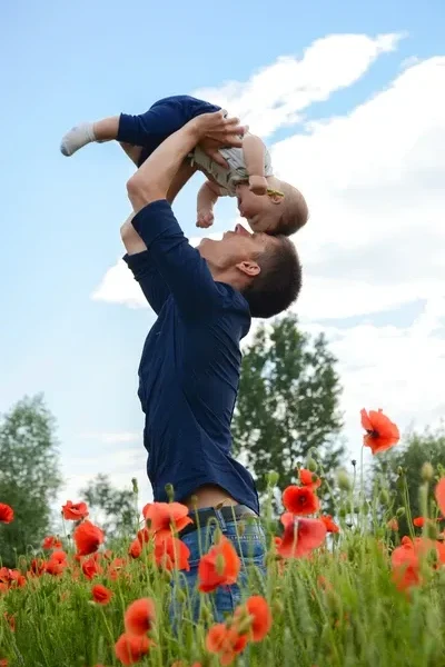 Man in blue long sleeve shirt carrying baby in white onesie by  Natasha Ivanchikhina on Unsplash